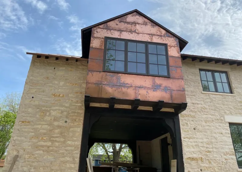 Copper metal panel facade on a stone building for Roof Repair in Belton